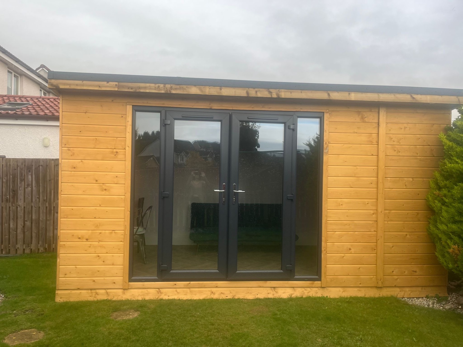 Composite-clad garden room with integrated decking, landscaped borders and patio area completed in Penicuik Midlothian
